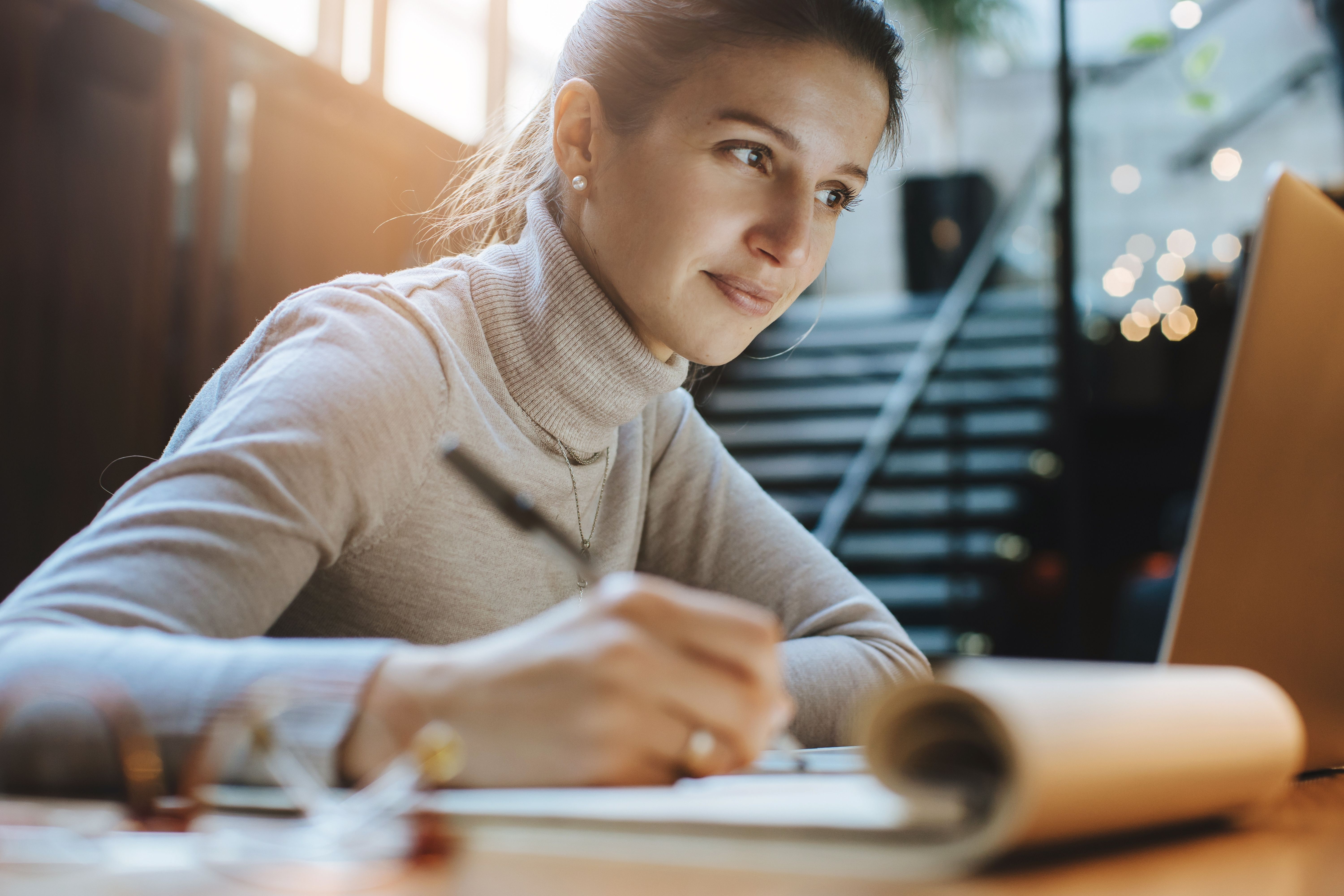women sitting in front of computer taking notes