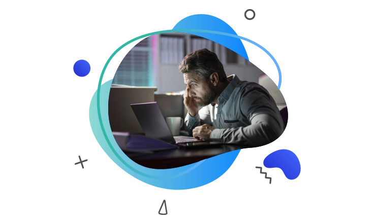 Focused man working on&nbsp;a&nbsp;laptop at&nbsp;night in&nbsp;a&nbsp;dimly lit office, appearing deep in&nbsp;thought.