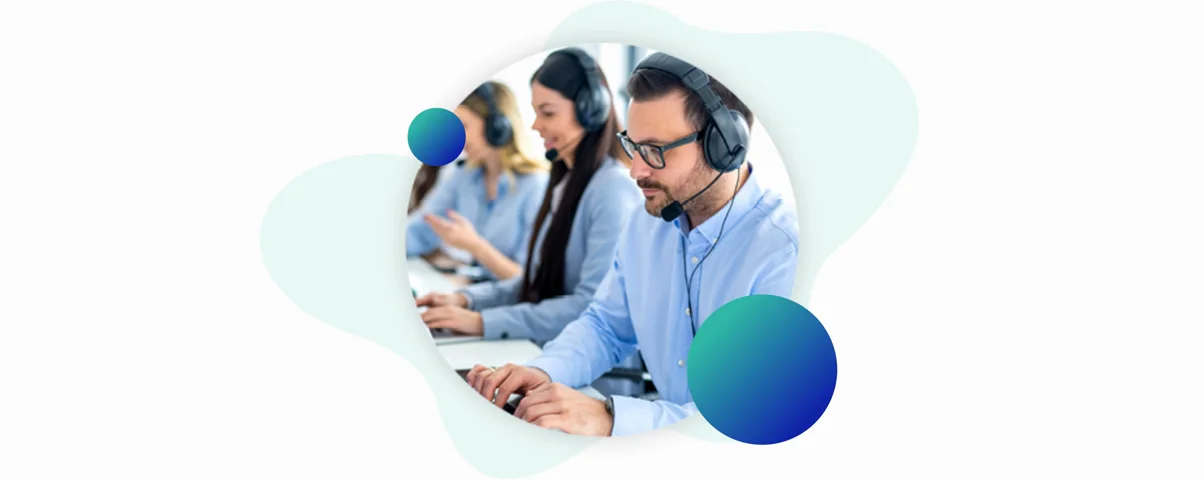 Call center operators wearing headsets and working on laptops in a bright, modern office environment.