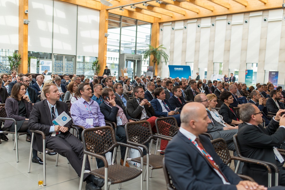 Audience engaged in&nbsp;a&nbsp;conference, seated in&nbsp;rows with people attentively listening and taking notes.